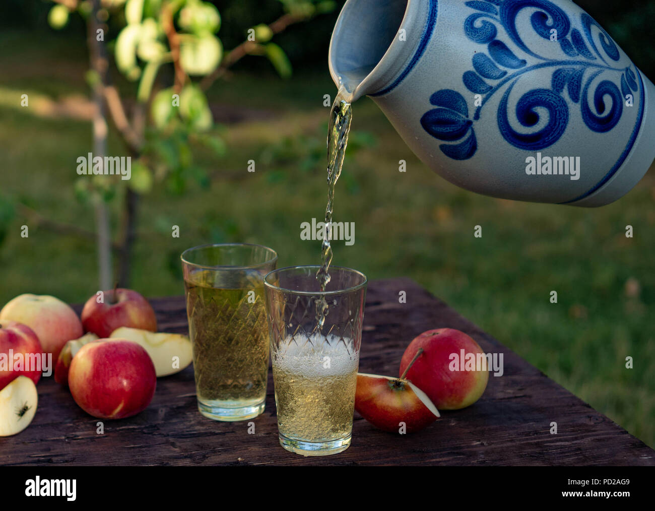 a man's hand pours Traditional apple wine in a refilled glass in the