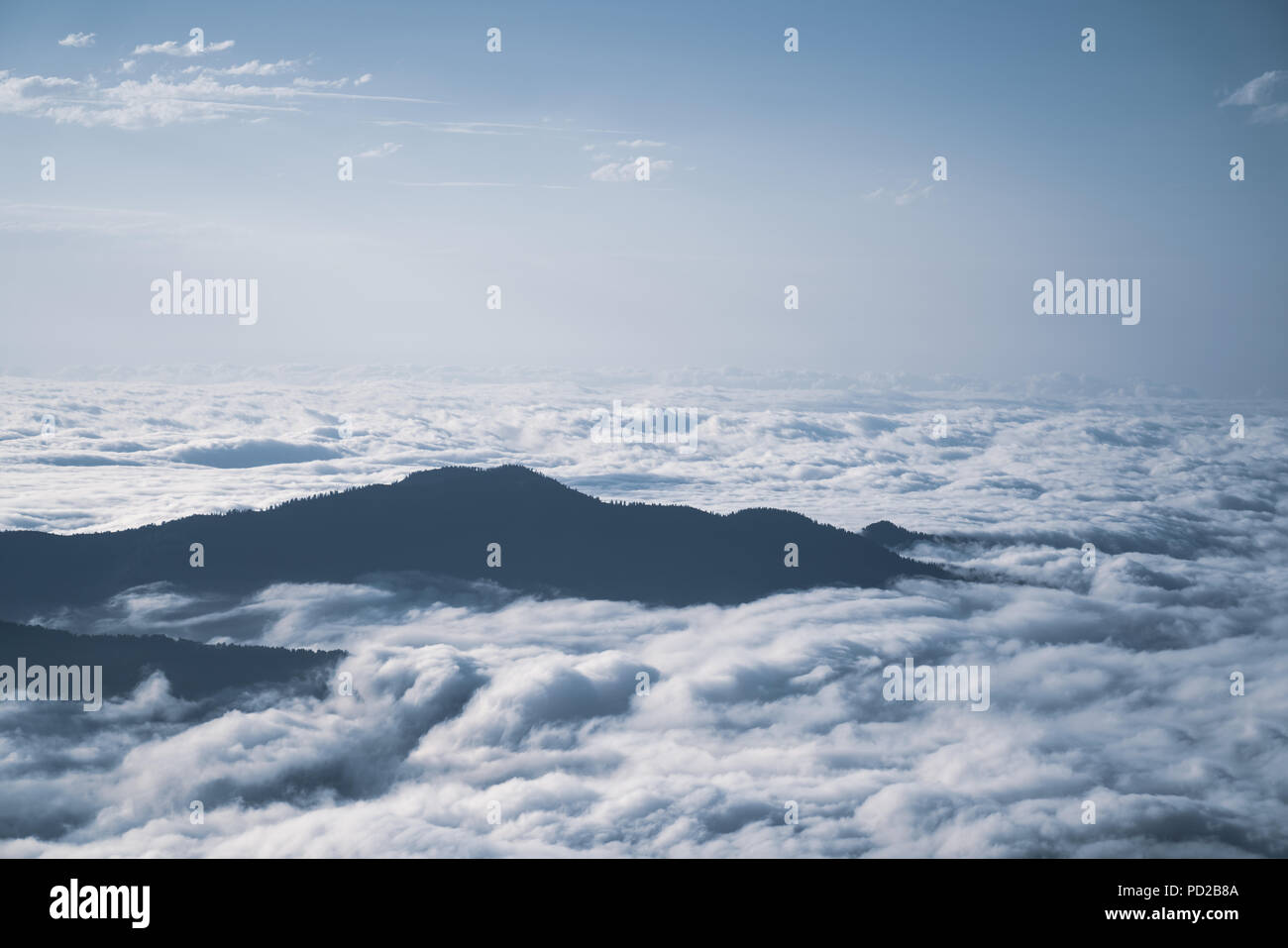 Mountain silhouette above the clouds at sunrise, view from the top view of mountains Stock Photo