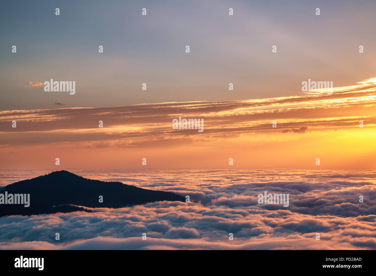 Mountain silhouette above the clouds at sunrise, view from the top view of mountains Stock Photo