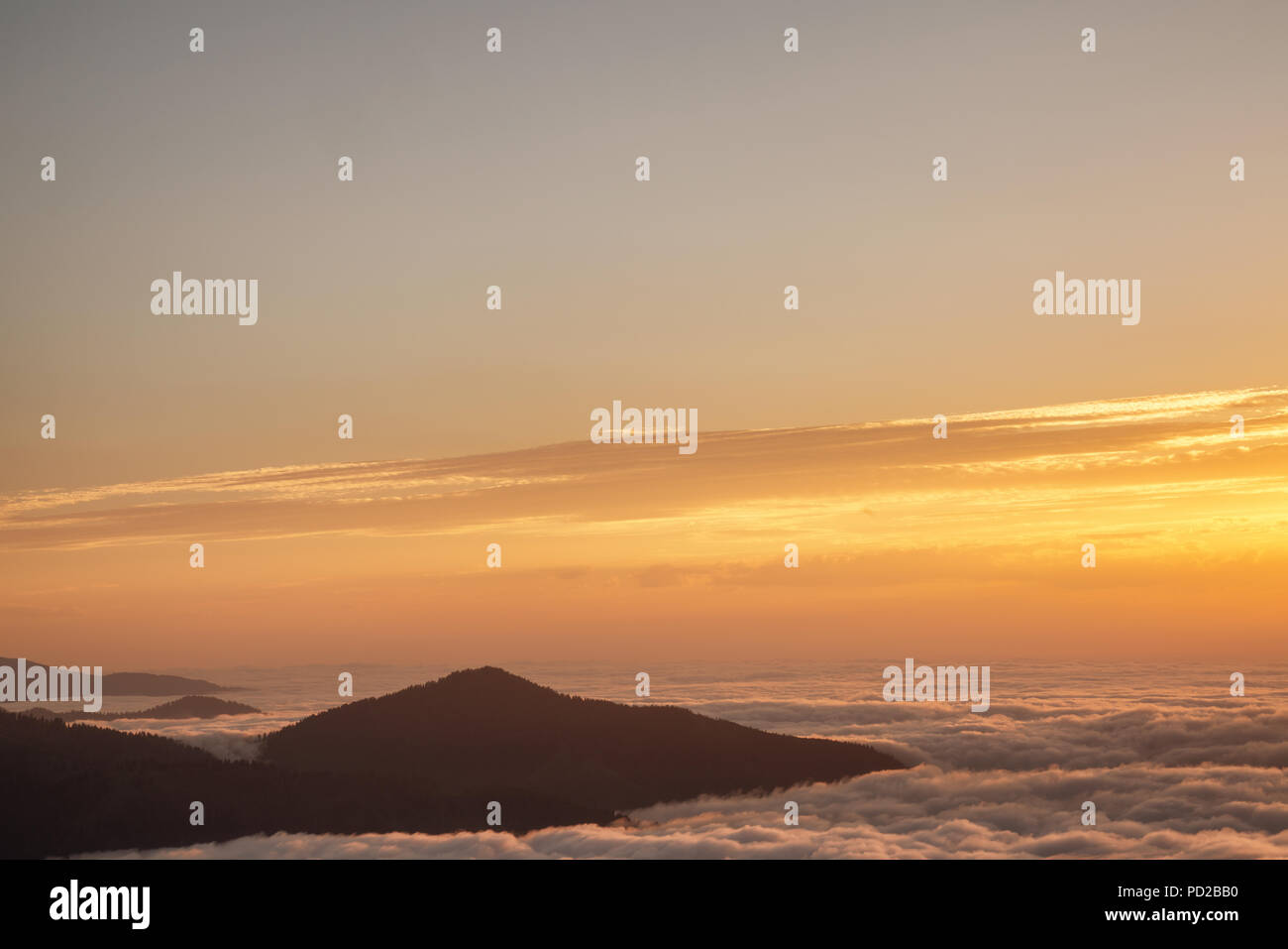 Mountain silhouette above the clouds at sunrise, view from the top view of mountains Stock Photo