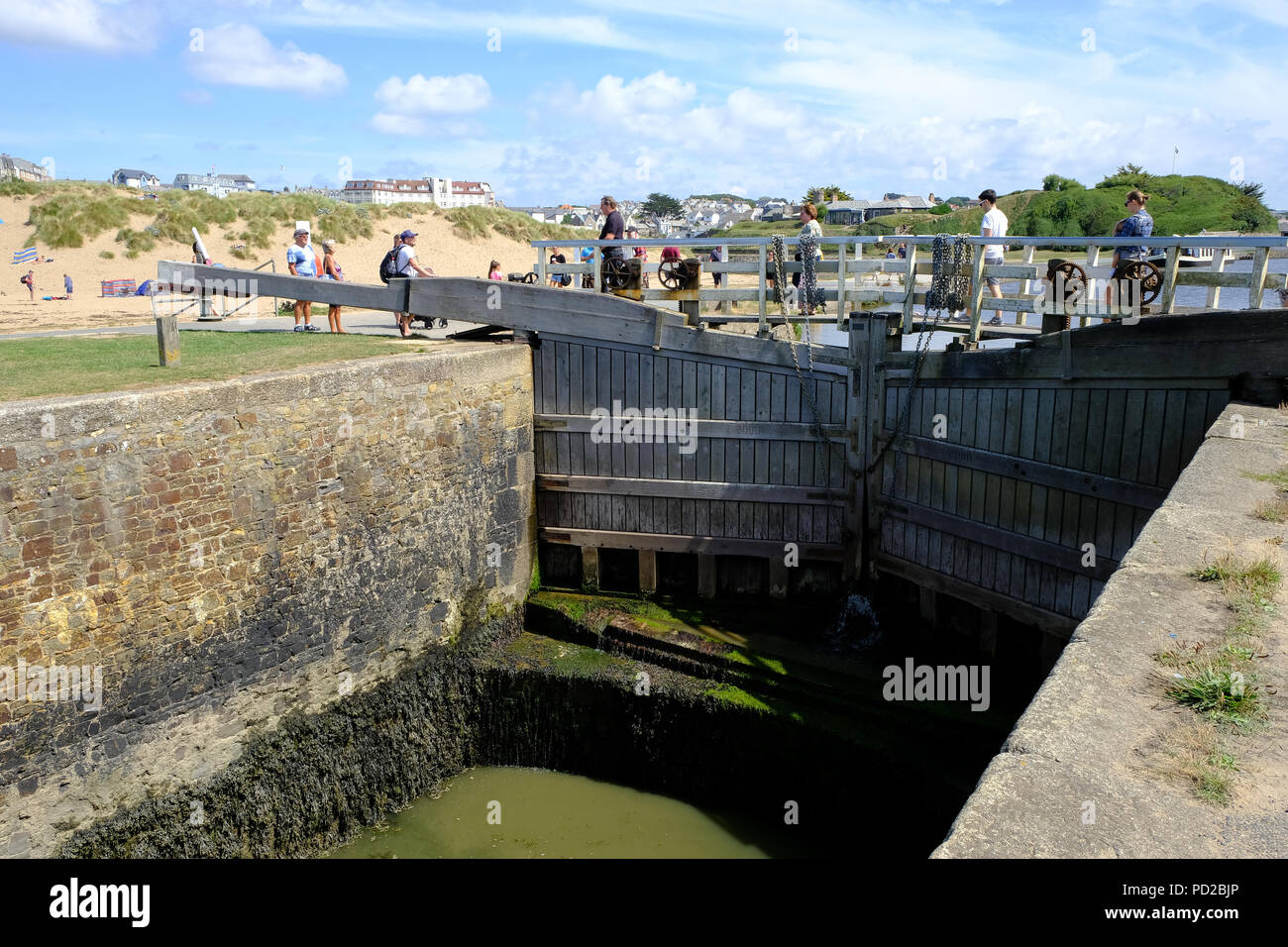 Bude Cornwall Uk Holidaymakers Enjoy The Hot Weather Walking Along The Bude Canal And Crossing The Sea Lock Bude Cornwall Uk Holidaymakers Enjoy The Hot Weather Walking Along The Bude Canal And Crossing The Sea Lock