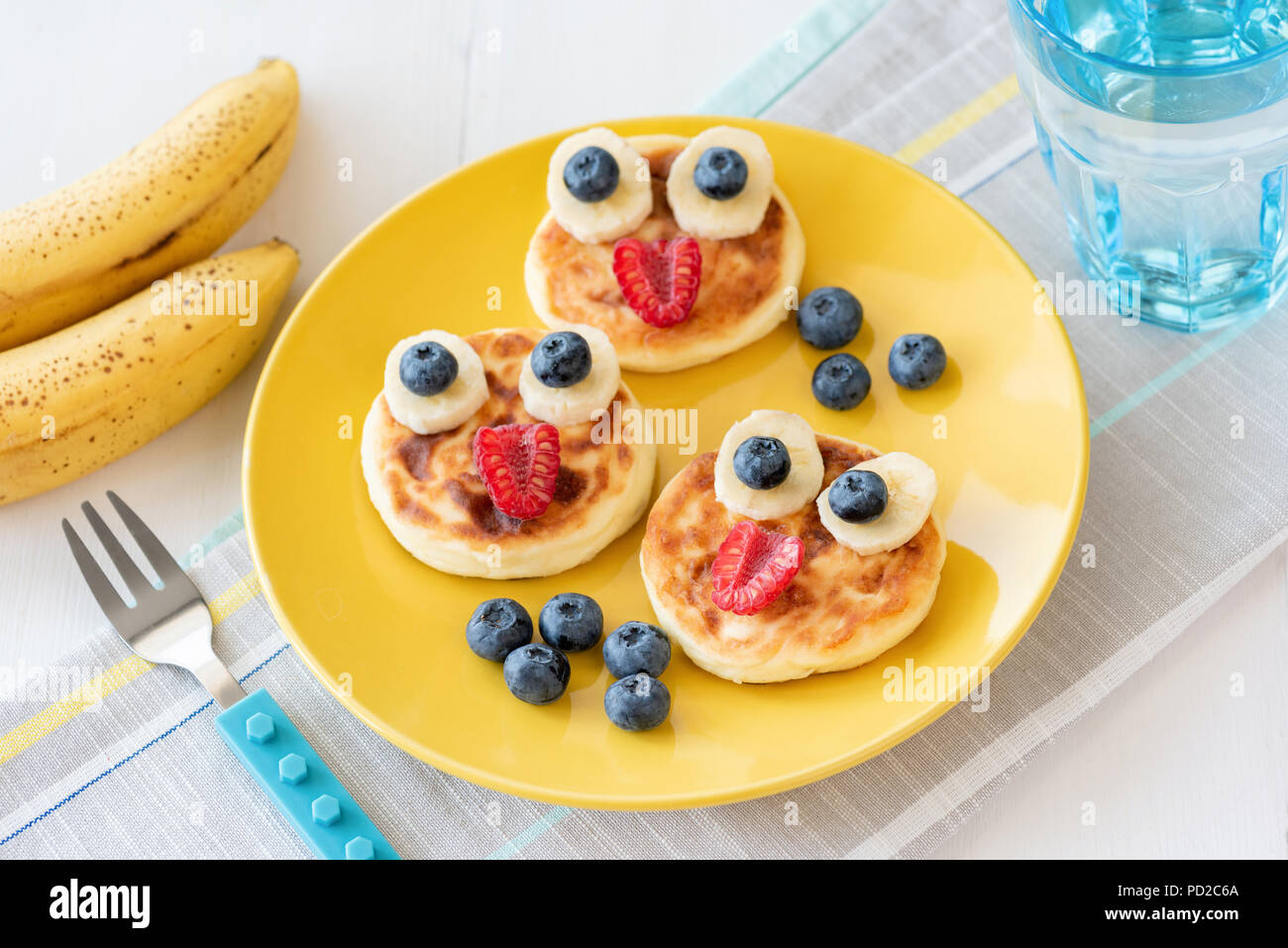 Fun food for kids. Pancakes with funny animal faces on colorful yellow
