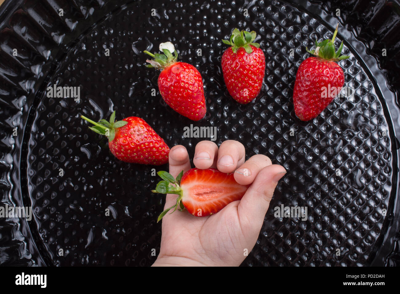 Juicy, sweet and ripe strawberry fruit in hand Stock Photo