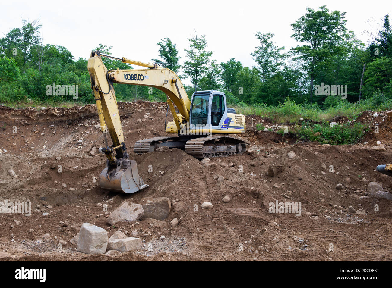 A Kobelco SK 250lc Hydraulic Excavator parked in a sand and gravel pit in the Adirondack Mountains, NY USA Stock Photo