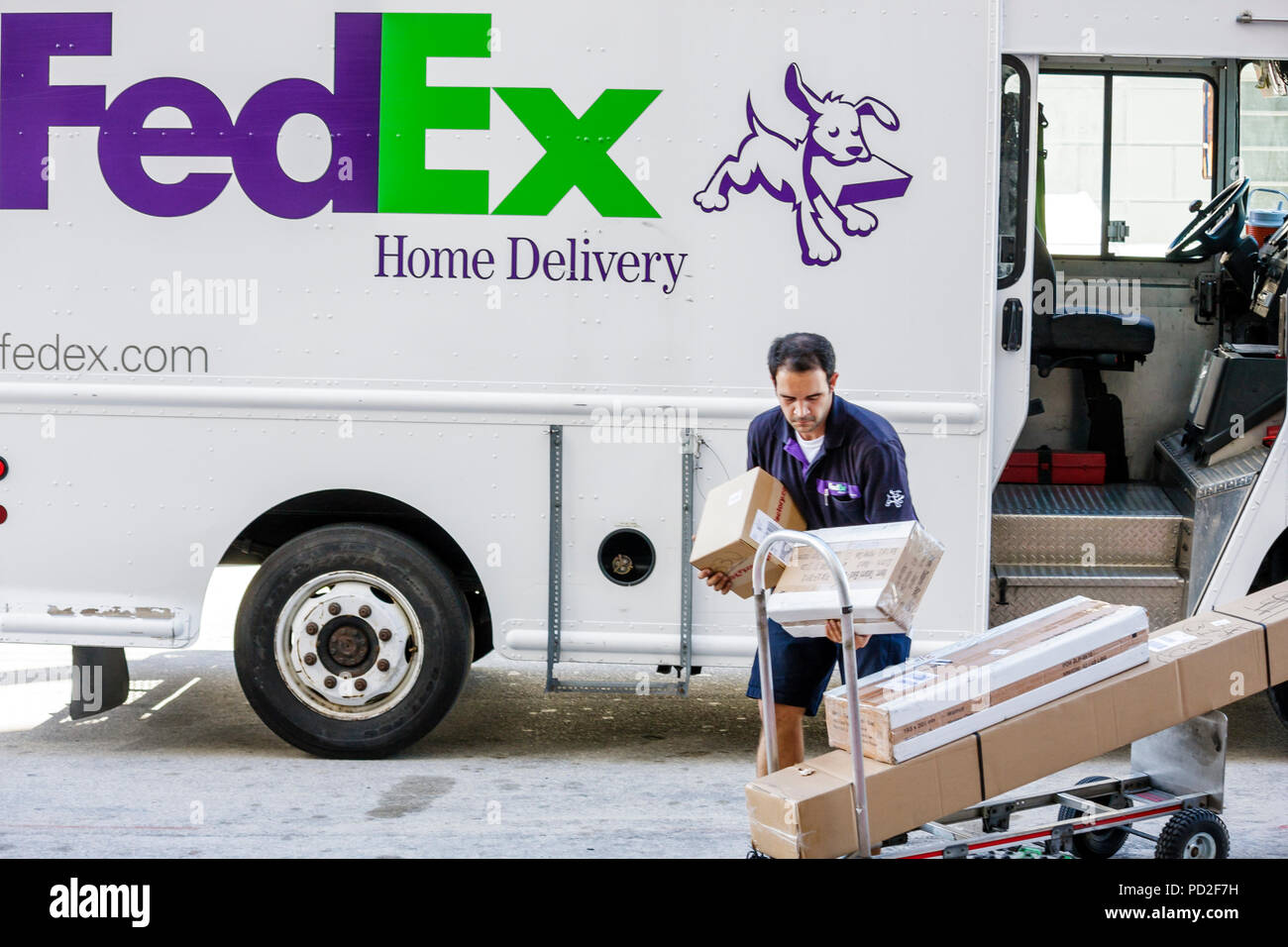 Miami Beach Florida,FedEx,worldwide,company,shipping,Hispanic ethnic man men male adult adults,worker,workers,courier,truck,driver,hand truck cart,dol Stock Photo