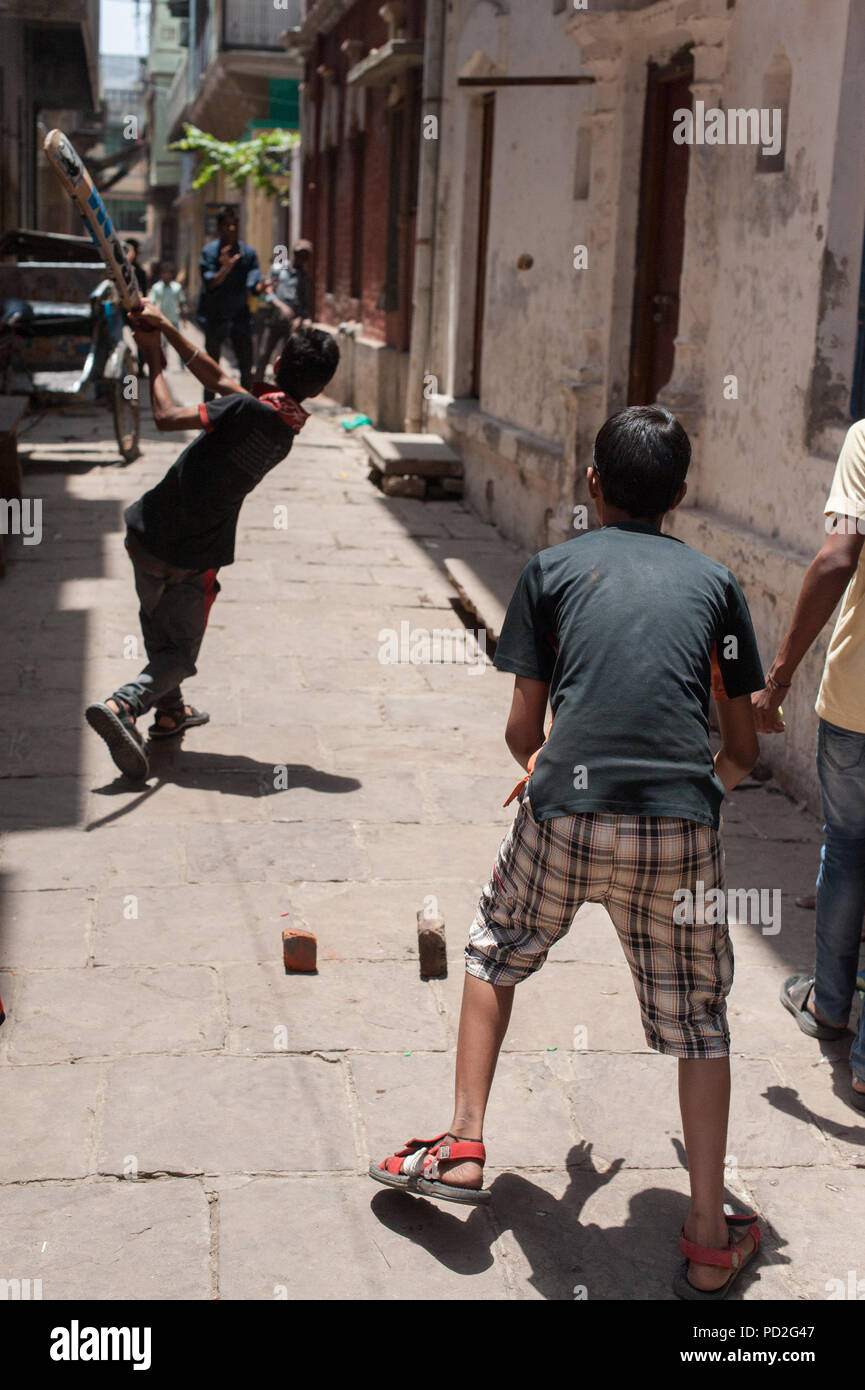 Boys play cricket in the streets of Varanasi, Uttar Pradesh, India Stock Photo