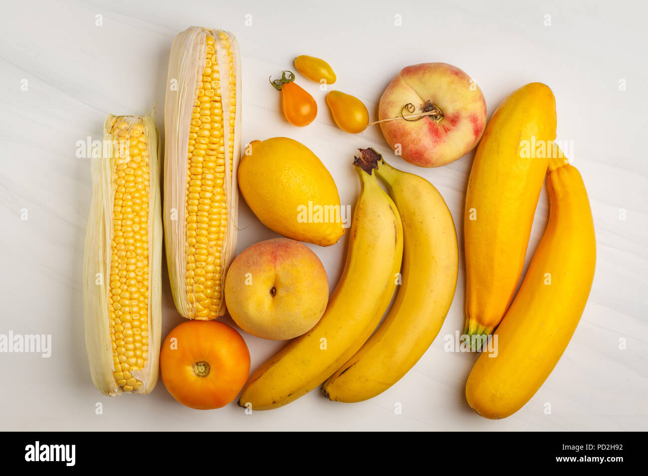 Assortment of yellow vegetables on a white background, top view. Fruits and vegetables containing carotene. Stock Photo