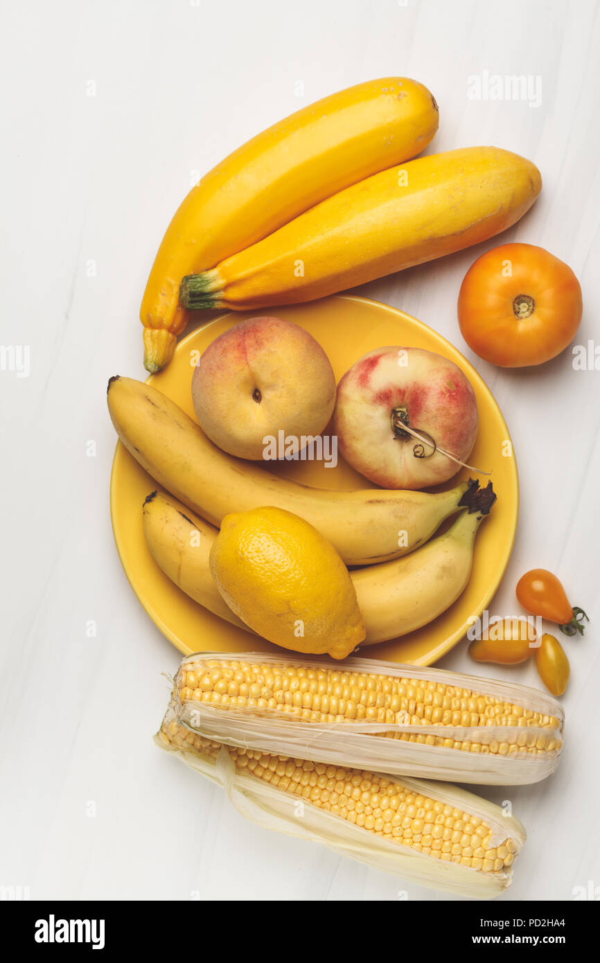 Assortment of yellow vegetables on a white background, top view. Fruits and vegetables containing carotene. Stock Photo