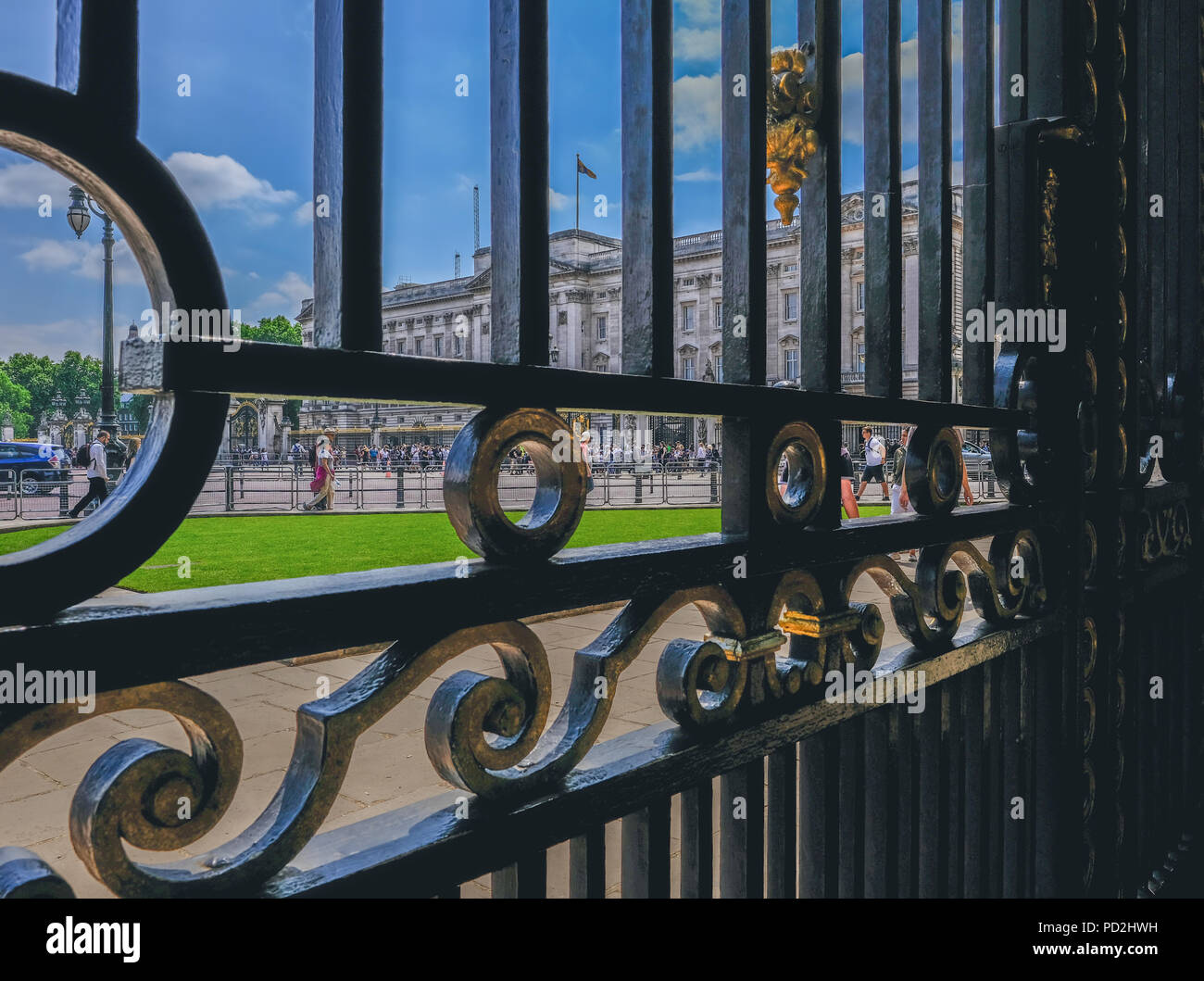 London, UK - June 8, 2018: Front view of Buckingham Palace from behind the black ornate South African Gates.  Taken on a bright sunny blue sky day. Stock Photo