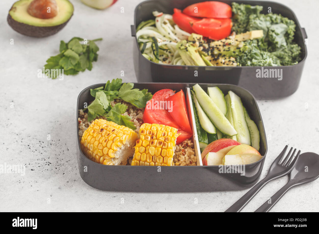 Healthy meal prep containers with quinoa, avocado, corn, zucchini noodles and kale. Takeaway food. White background, top view. Stock Photo