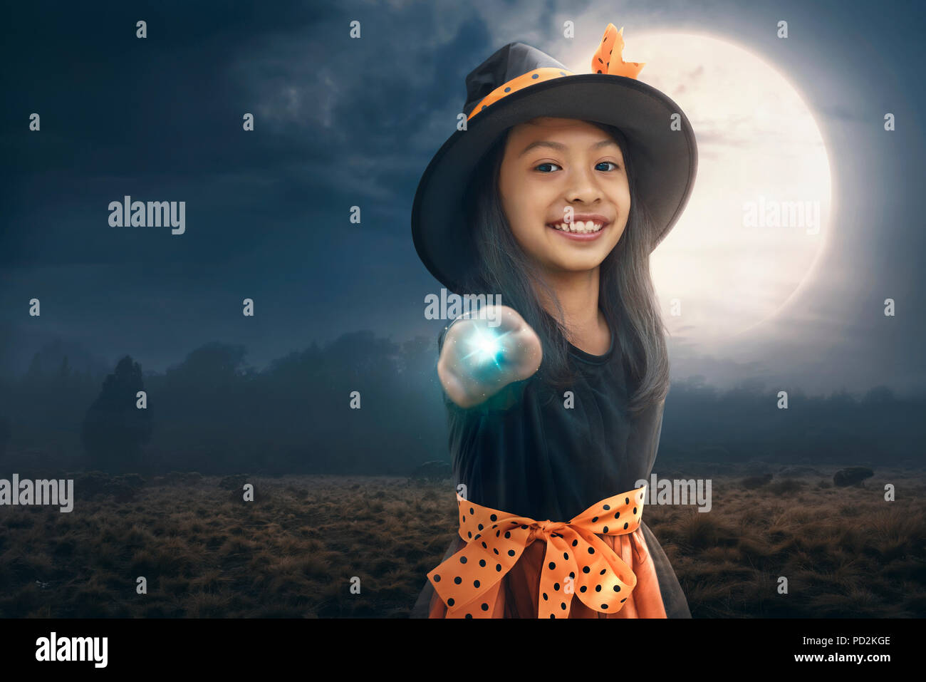 Smiling asian child girl using her magic power with moonlight background Stock Photo