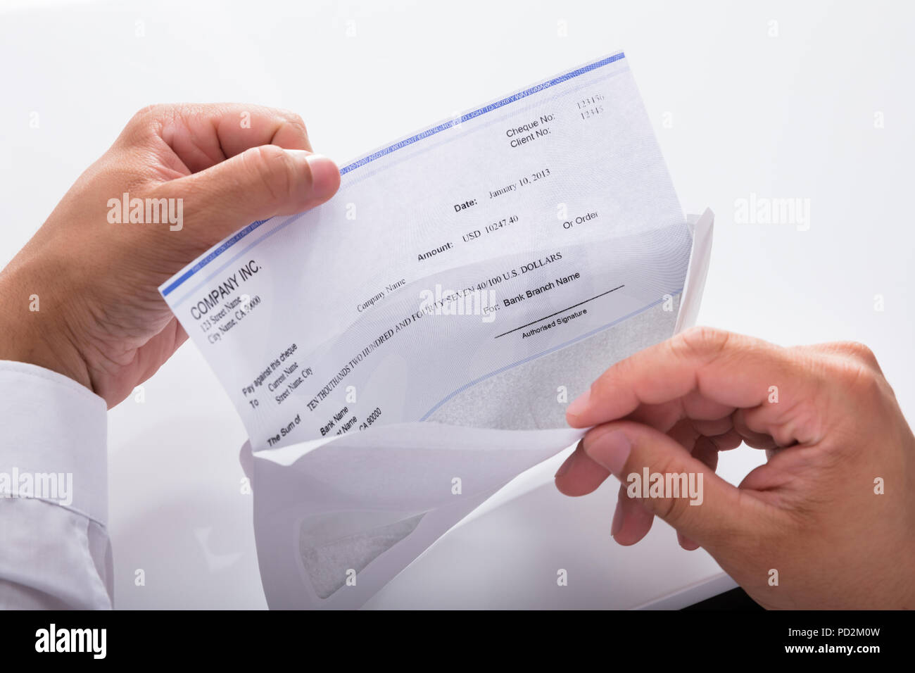 Close-up of a businessman's hand opening envelope with paycheck Stock Photo