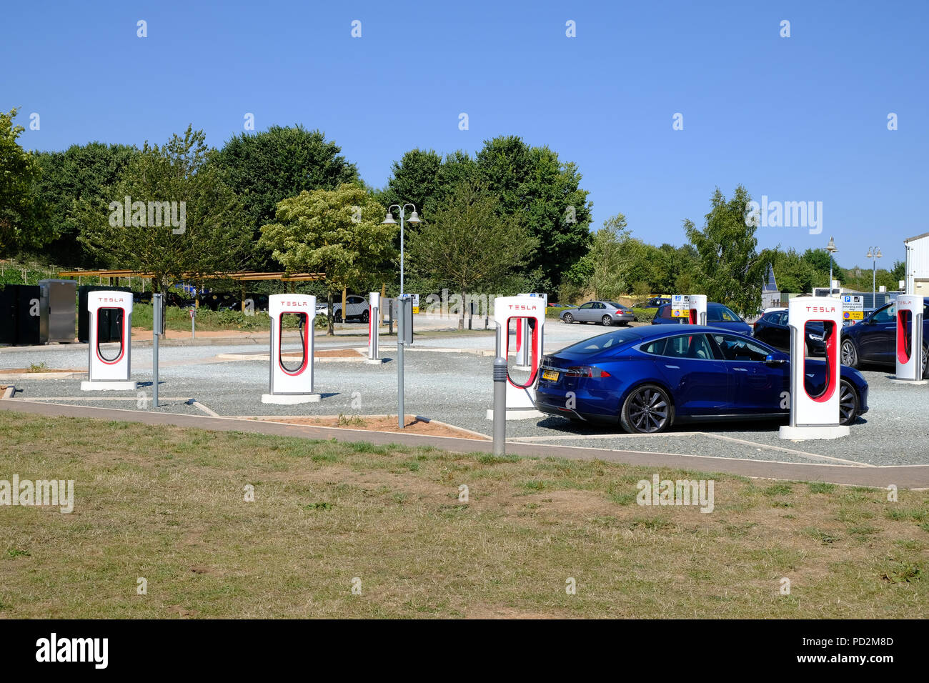Topsham, Devon, UK. Tesla Model S charging at a Tesla supercharger station in Darts Farm Stock Photo