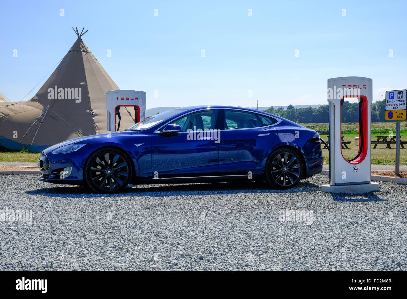 Topsham, Devon, UK. Tesla Model S charging at a Tesla supercharger station in Darts Farm Stock Photo