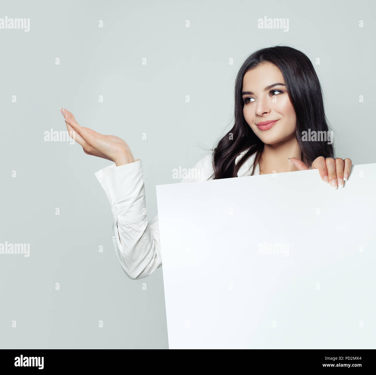 Young woman student with empty open hand and white blank paper banner background with copy space. Business woman smiling, business and education conce Stock Photo