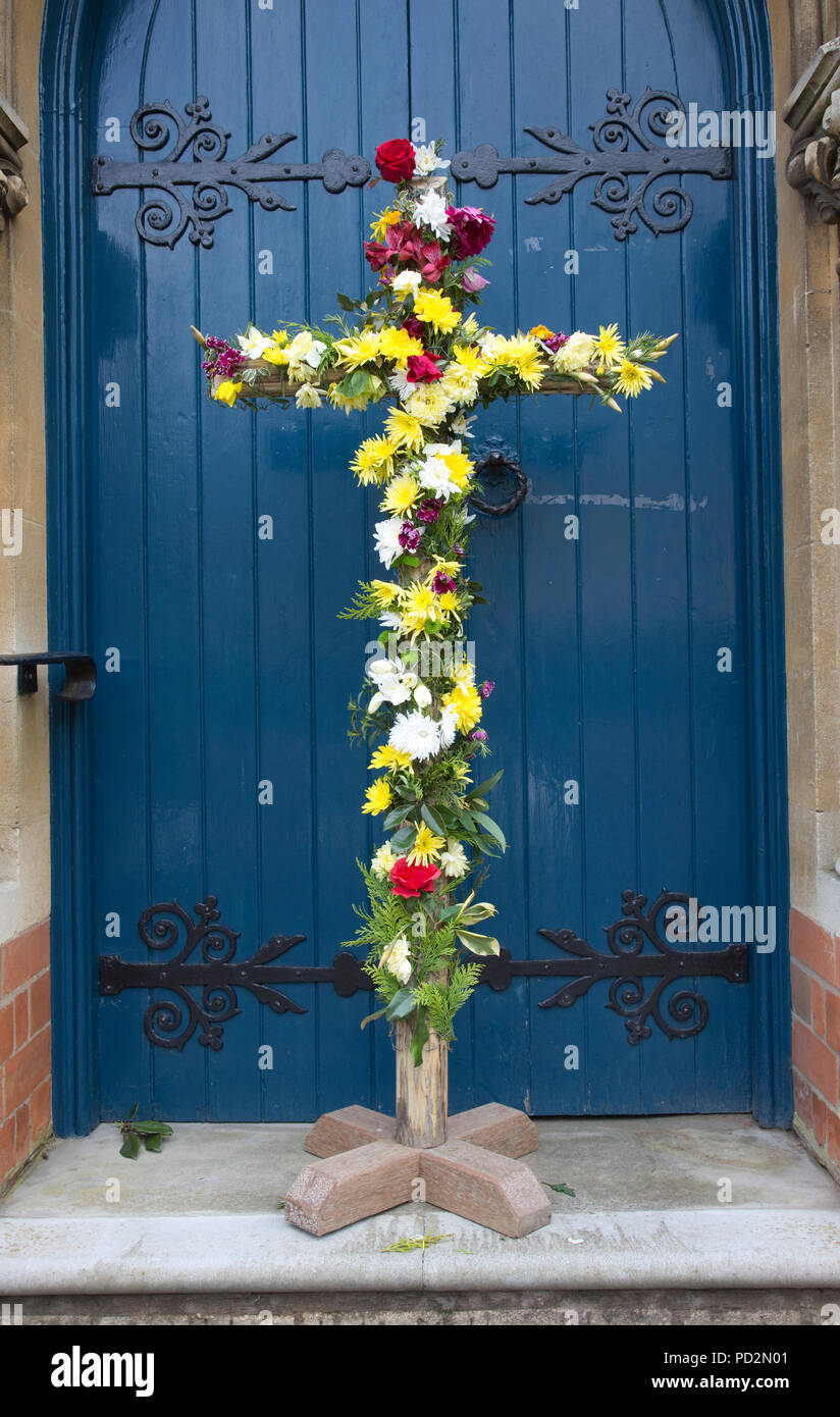 Wooden Easter cross decorated with flowers outside church door Mickleton Methodist Church UK Stock Photo