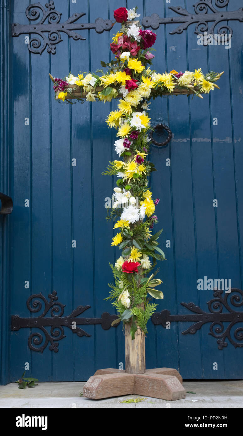 Wooden Easter cross decorated with flowers outside church door Mickleton Methodist Church UK Stock Photo