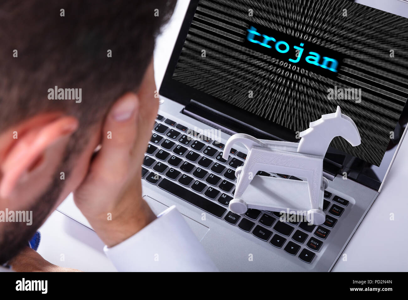 Businessman With Laptop Screen Showing Trojan Text With Binary Digits Stock Photo