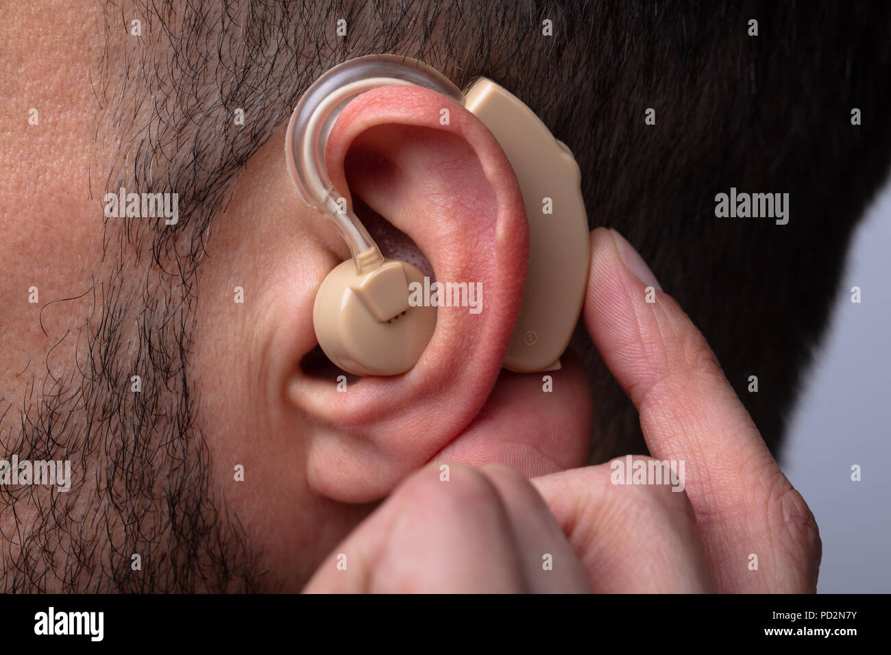 Close-up Of A Man's Hand Inserting Hearing Aid In His Ear Stock Photo ...
