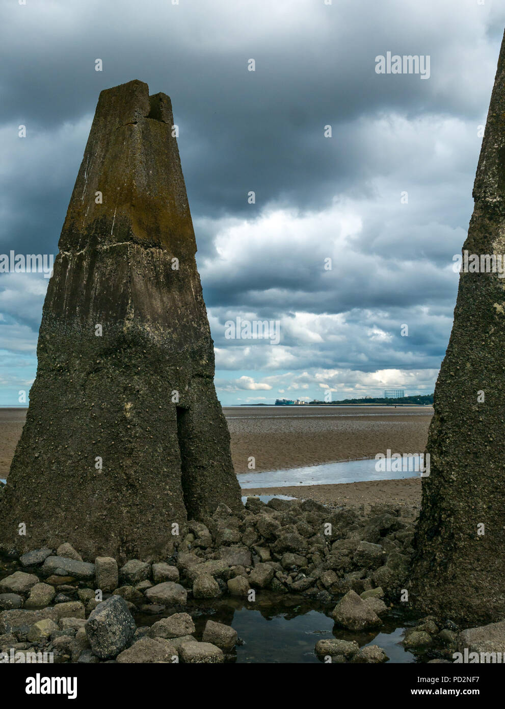 Remains of World War II concrete anti shipping barrier pylons in the Firth of Forth at low tide, Cramond, Edinburgh, Scotland, UK Stock Photo