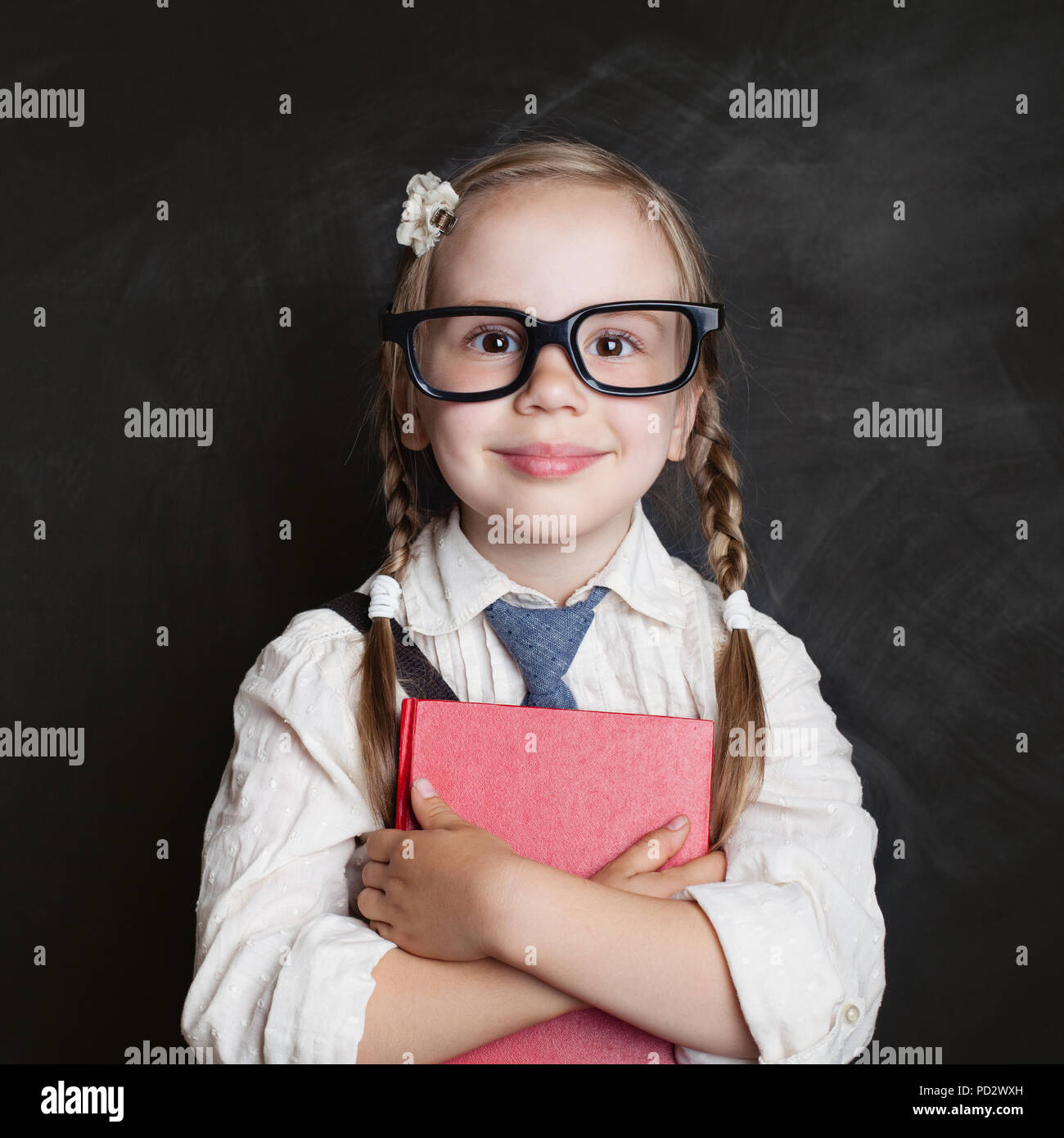 Happy child with book on chalkboard background. Back to school, elementary school lesson and education concept Stock Photo