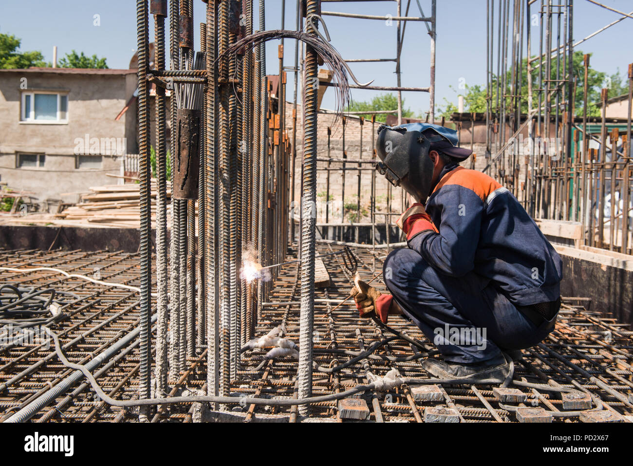 construction worker welding metal rebar for the pouring of foundation. candid, real people Stock
