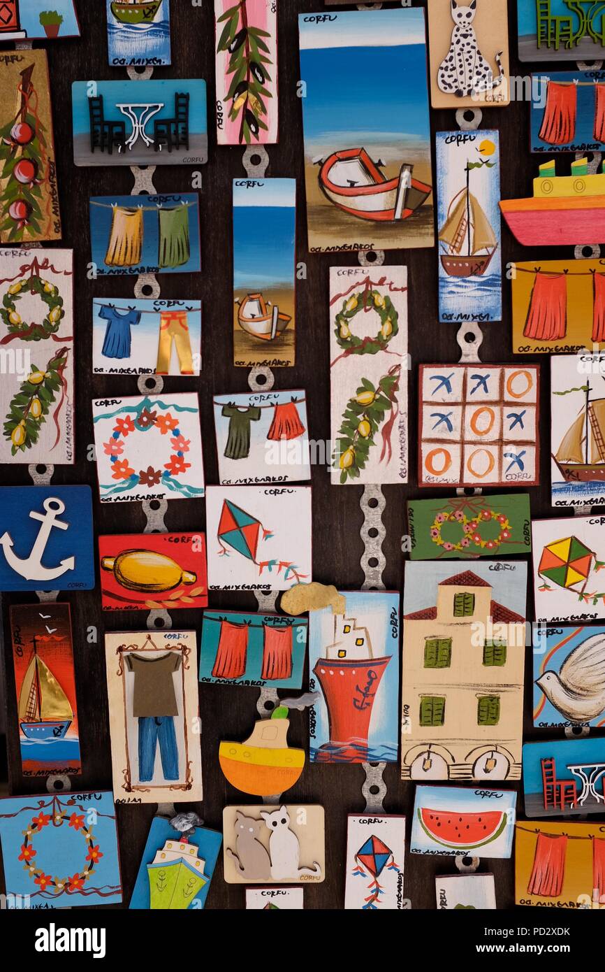 Close up of board of colourful fridge magnets showing local scenes and symbols in souvenir shop, Corfu Island, Greece Stock Photo