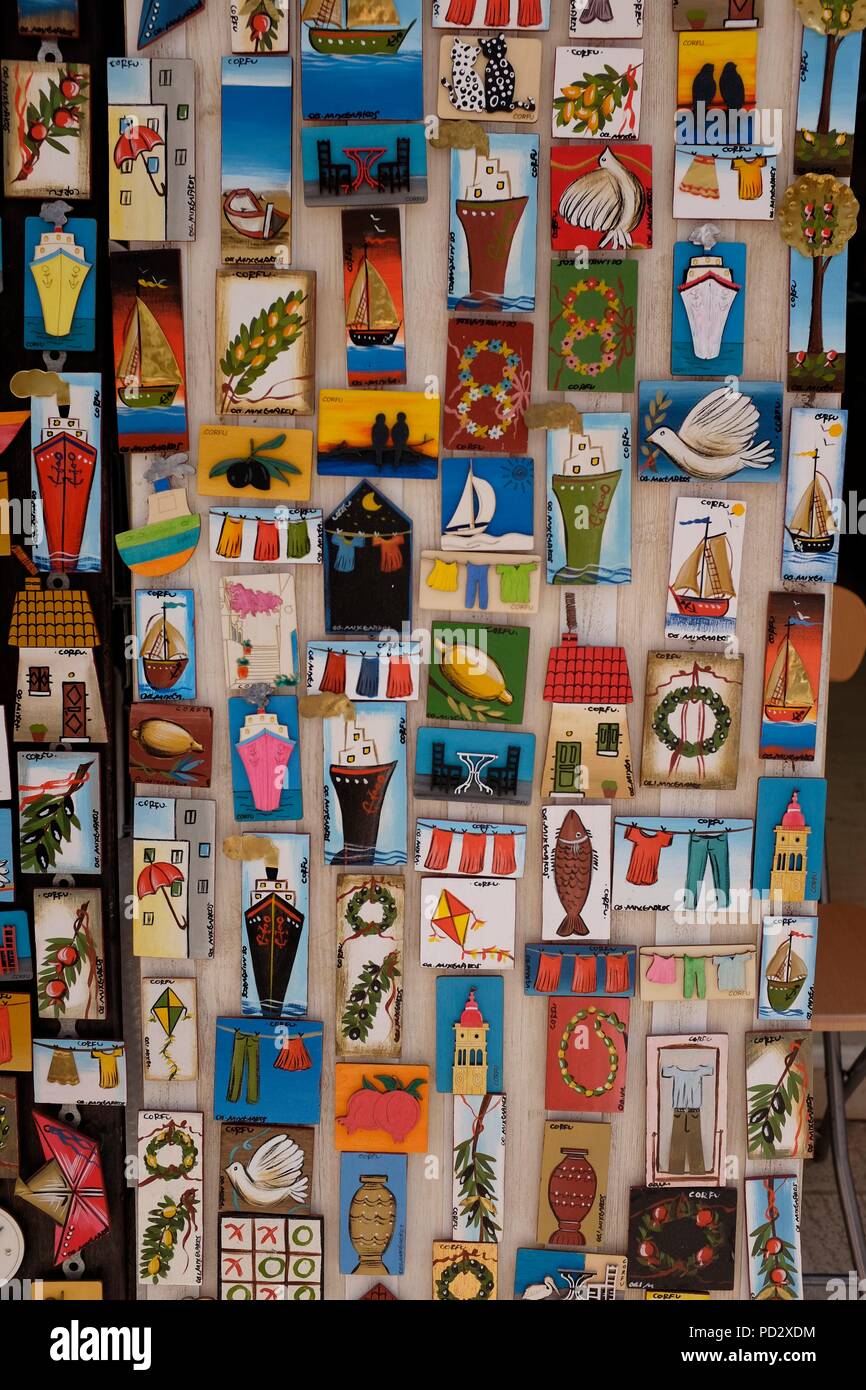 Close up of board of colourful fridge magnets showing local scenes and symbols in souvenir shop, Corfu Island, Greece Stock Photo