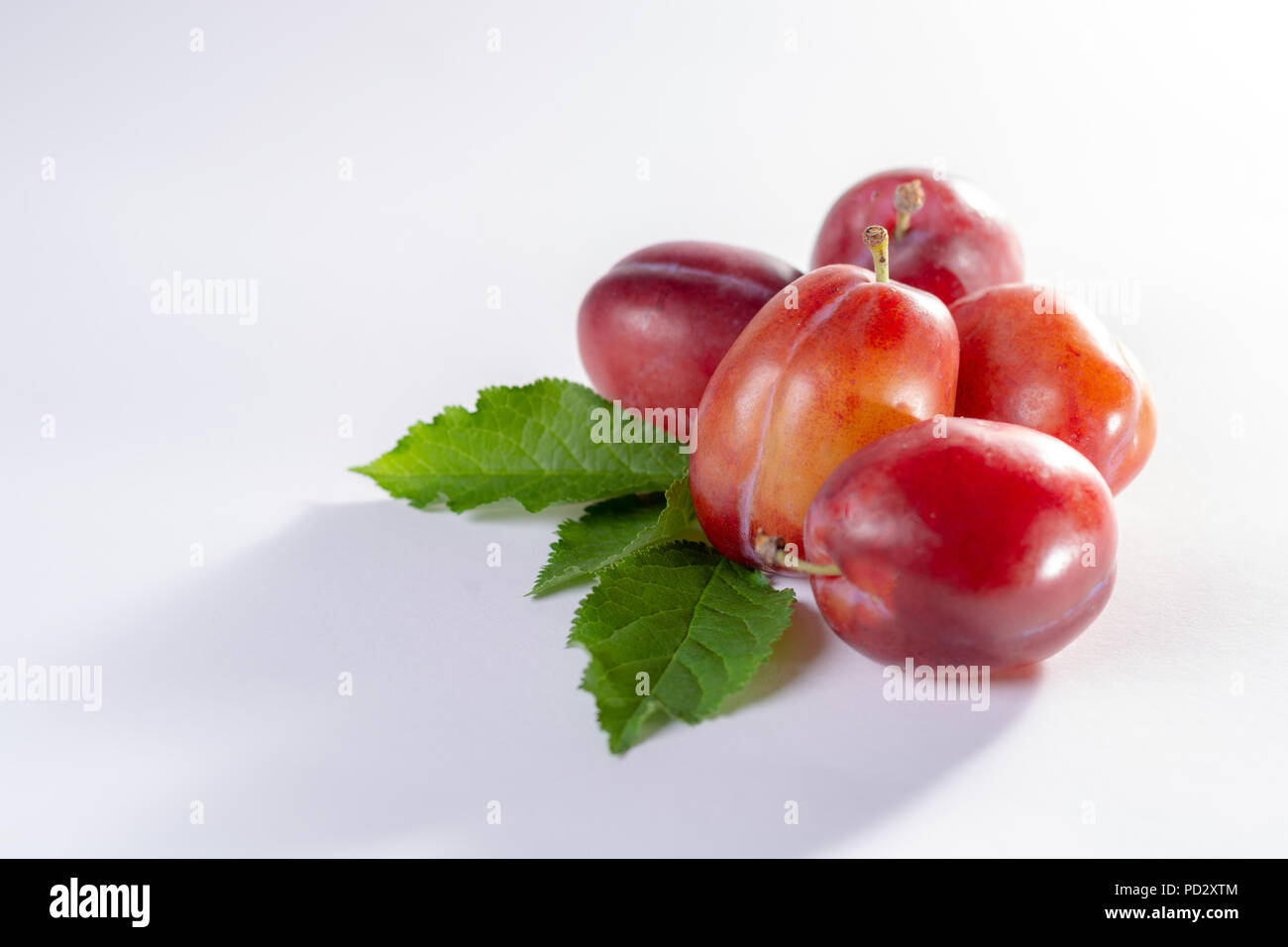 Group of ripe oval Victoria plums from England on white background with leaves Stock Photo Alamy