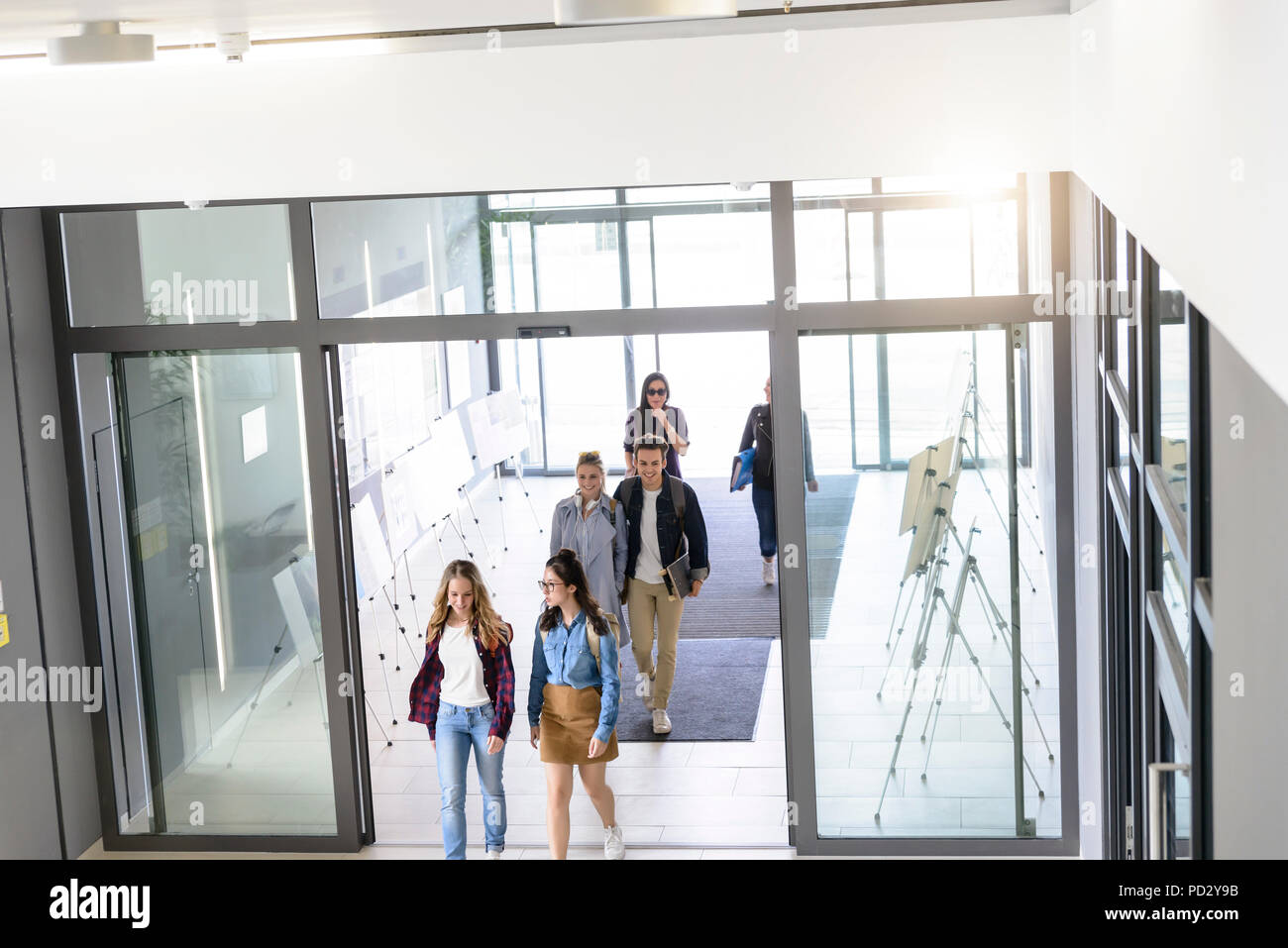 Students entering college building by glass doors Stock Photo