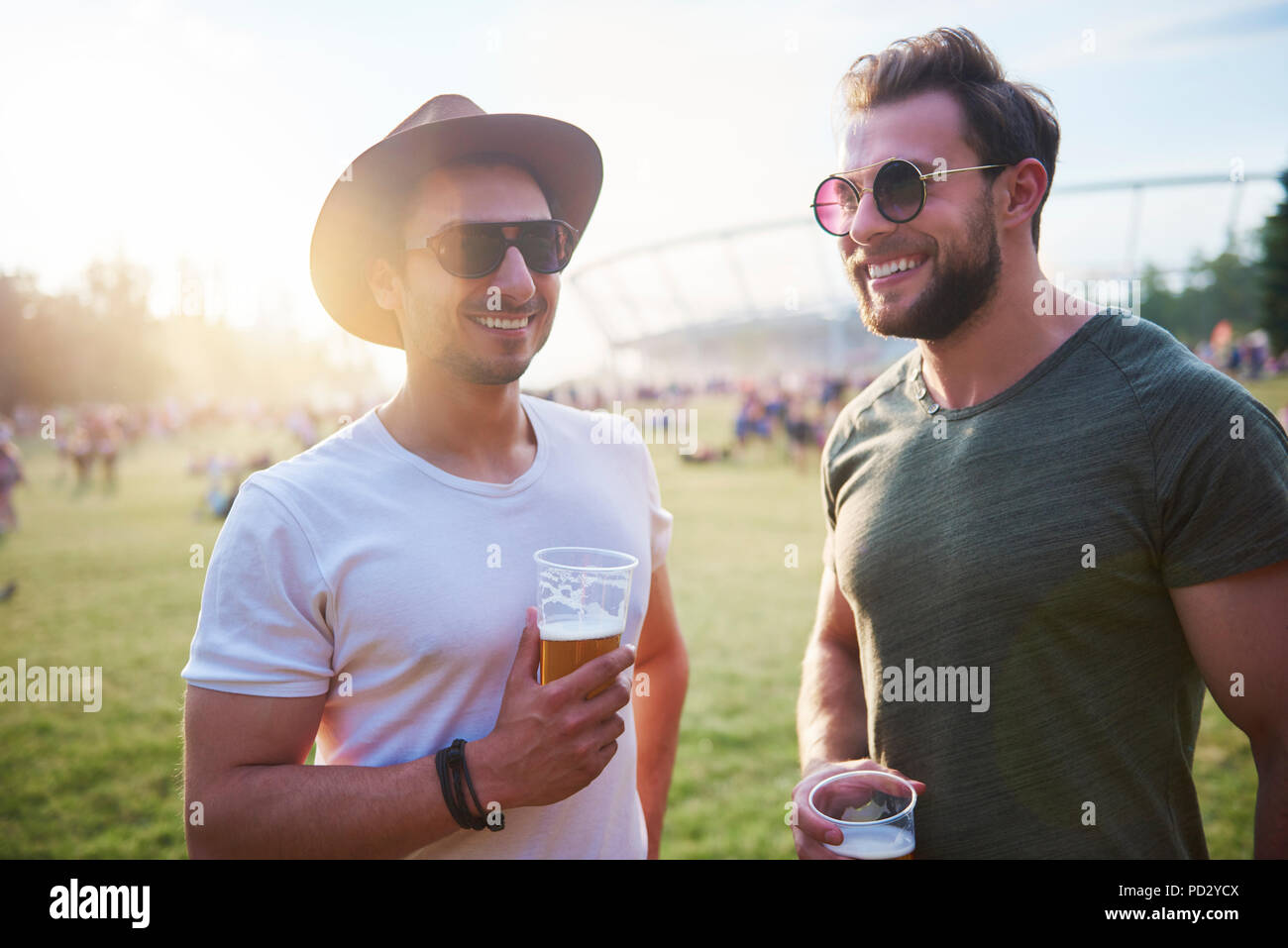 Two young male friends with glasses of beer at Holi Festival Stock Photo