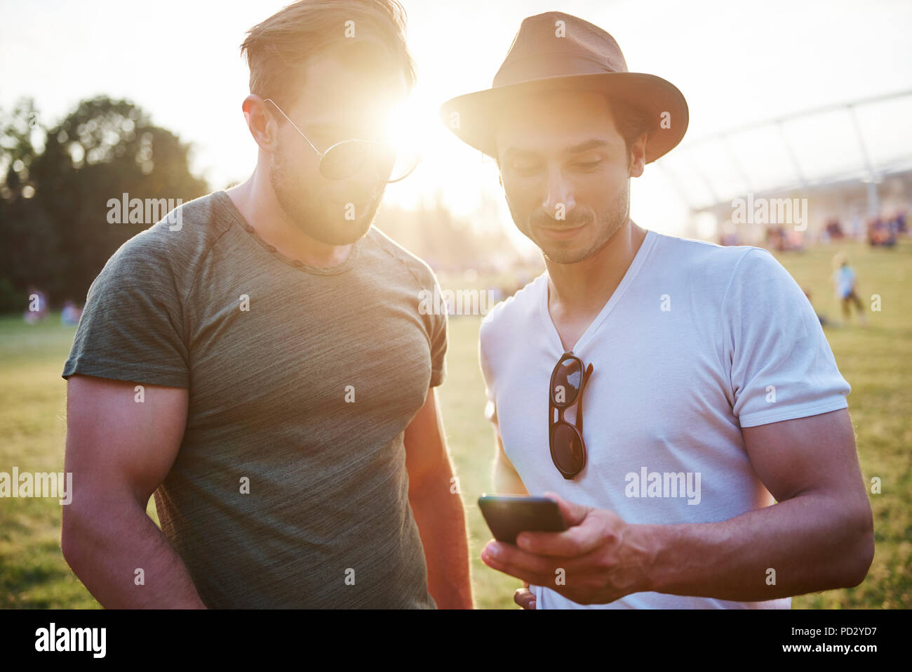 Two young men looking at smartphone at Holi Festival, detail of feet Stock Photo
