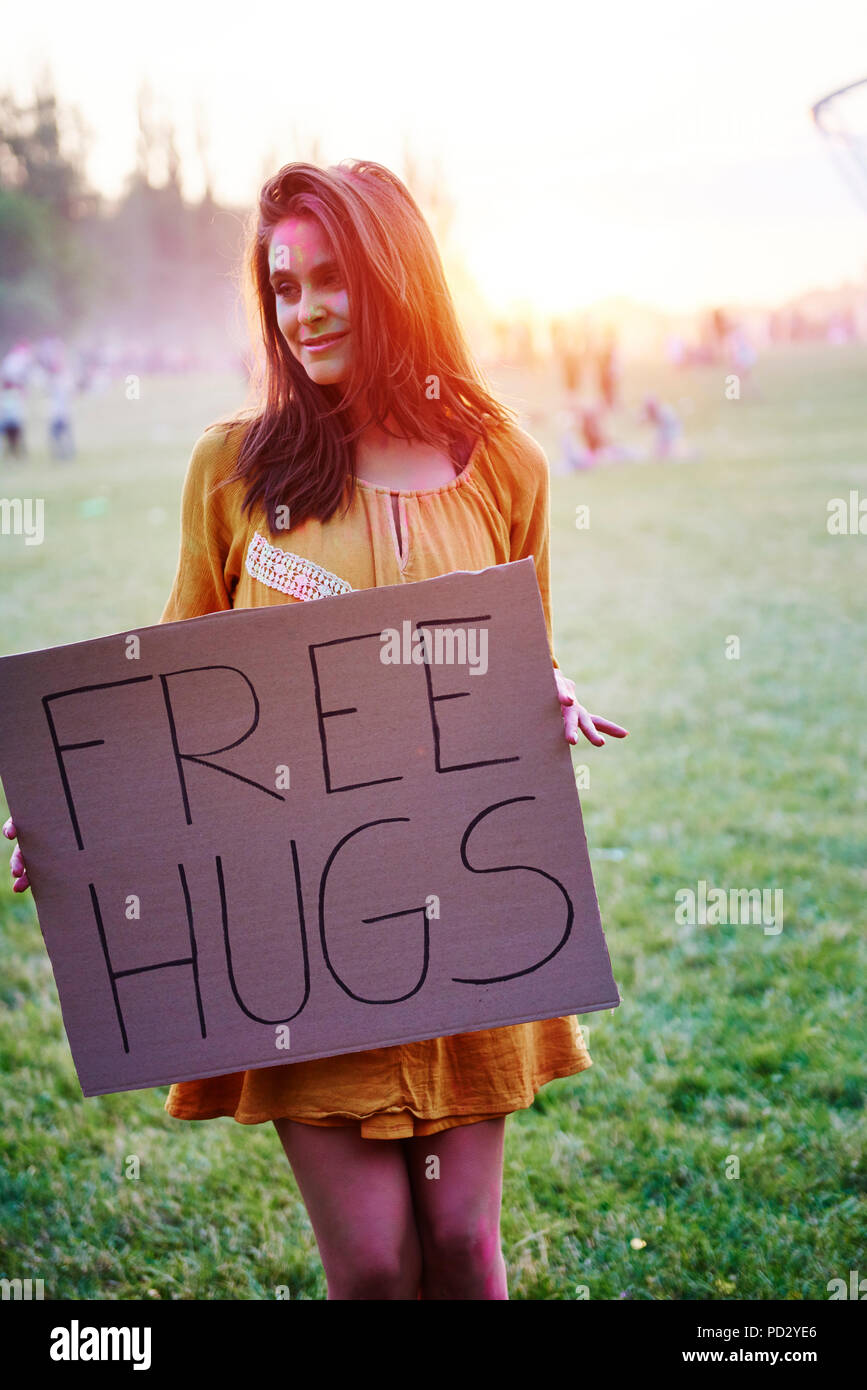 Young woman holding free hug sign at Holi Festival Stock Photo