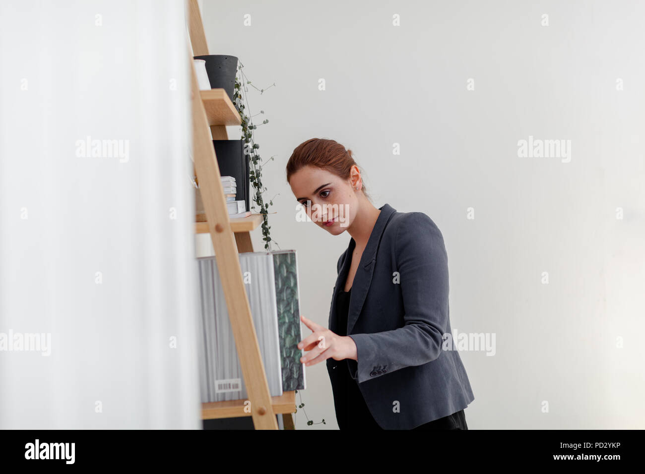 Woman looking for folder in home office Stock Photo