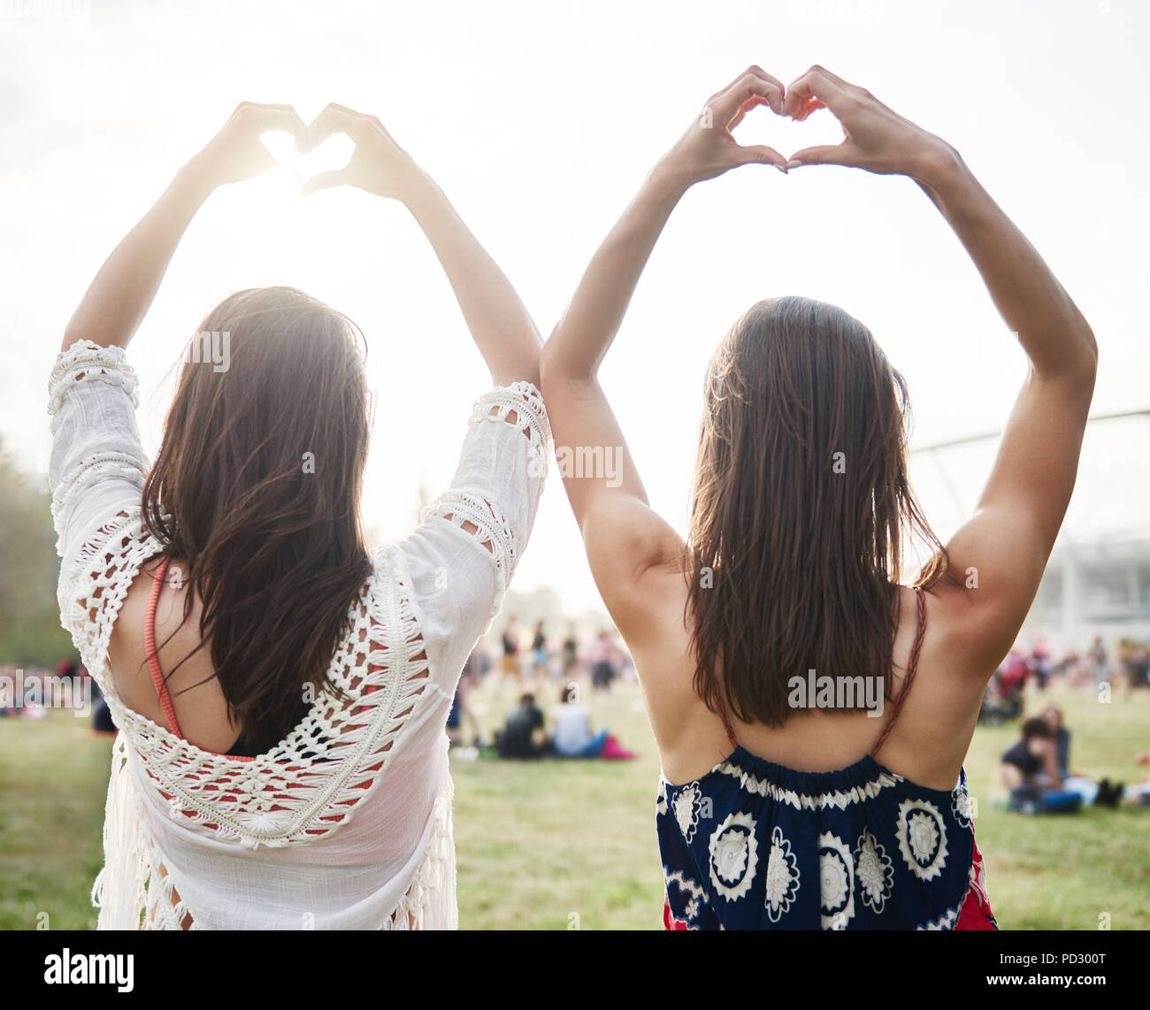 Friends dancing with arms raised in music festival Stock Photo