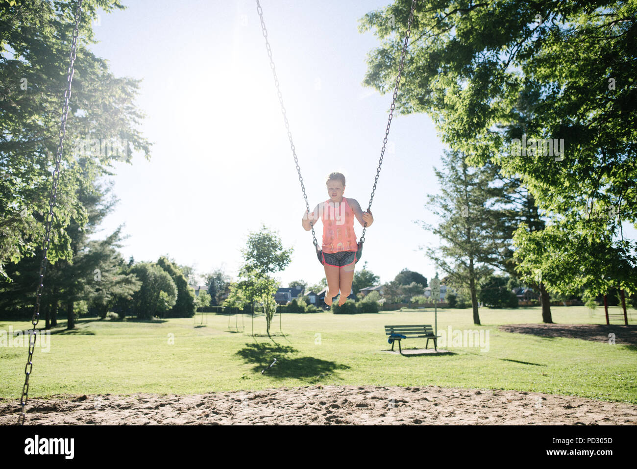 Girl on swing in playground, Kingston, Canada Stock Photo