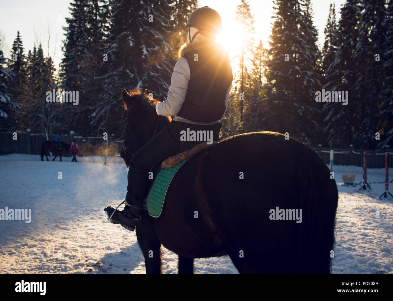 Girl riding horse at sunset Stock Photo