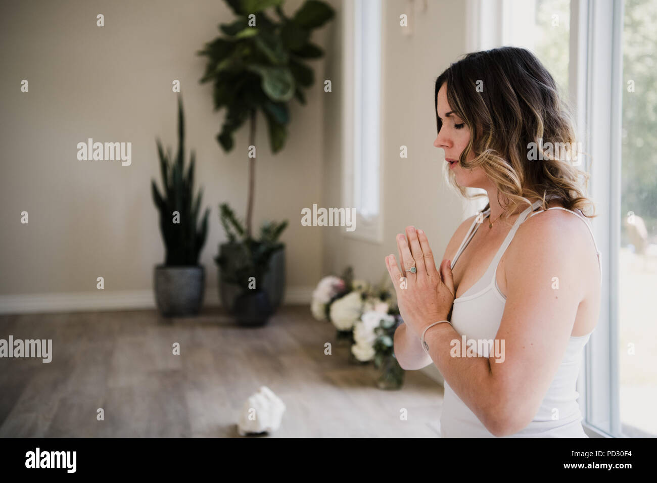 Woman with palms closed in meditation posture Stock Photo