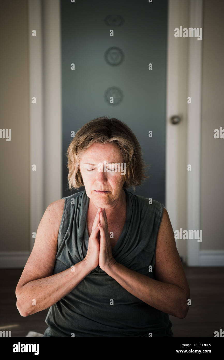 Woman with palms closed in meditation posture Stock Photo