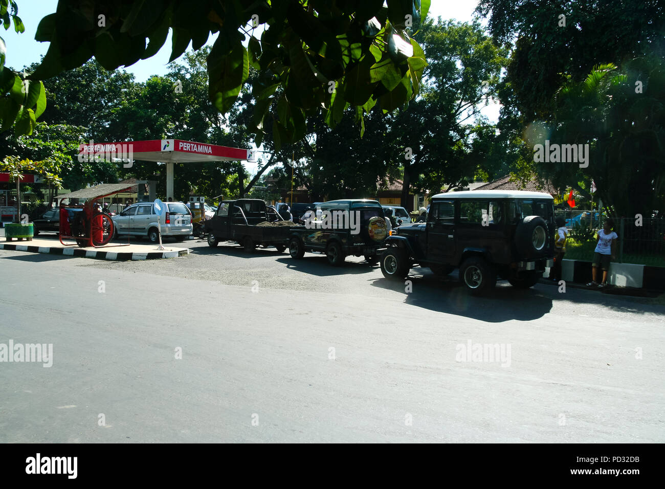 Lombok, Indonesia. A line of vehicles waits to fill up with petrol at a Pertamina petrol station on the island of Lombok. Stock Photo