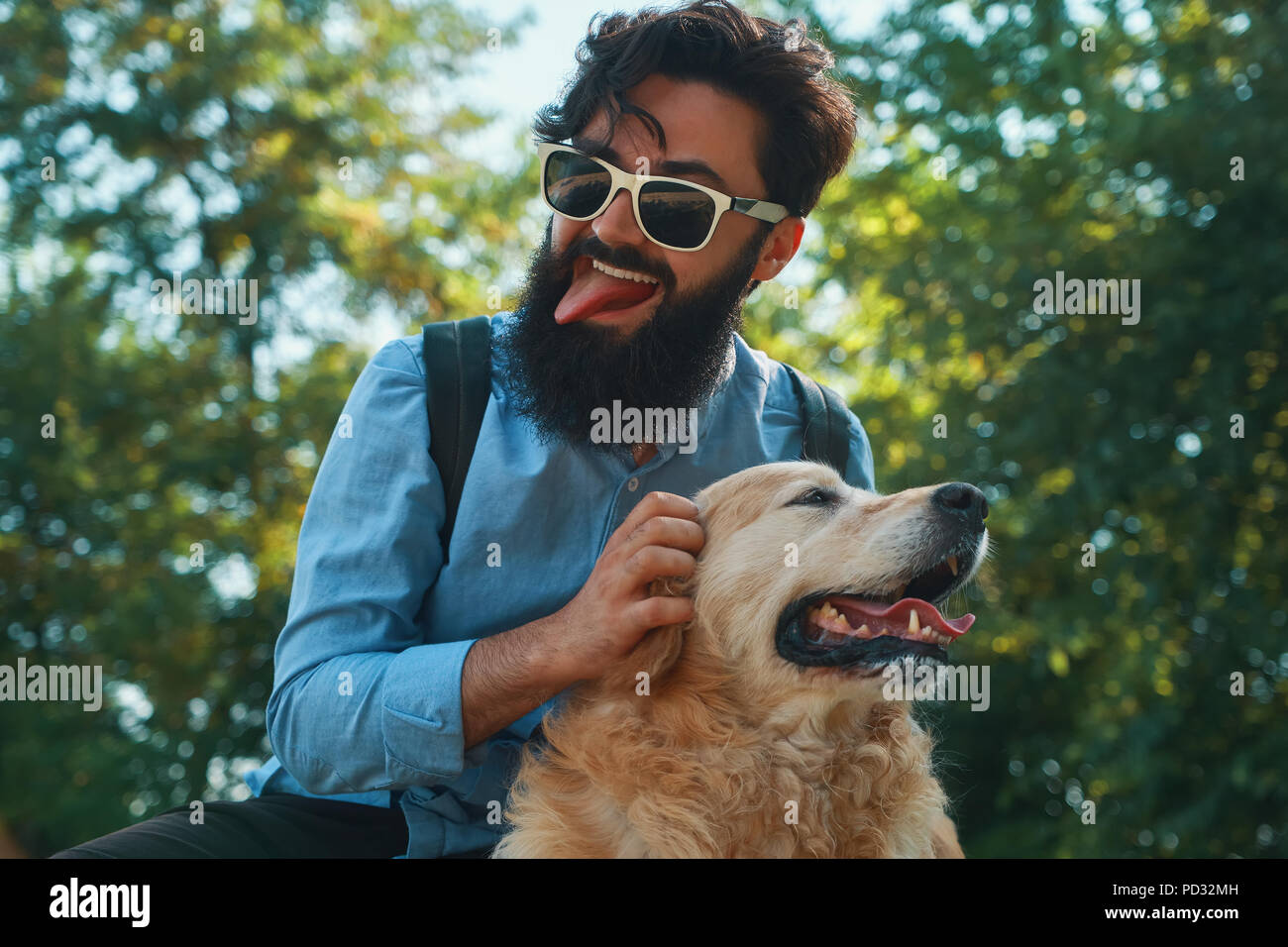 Man and dog having fun, playing, making funny faces while restin Stock Photo