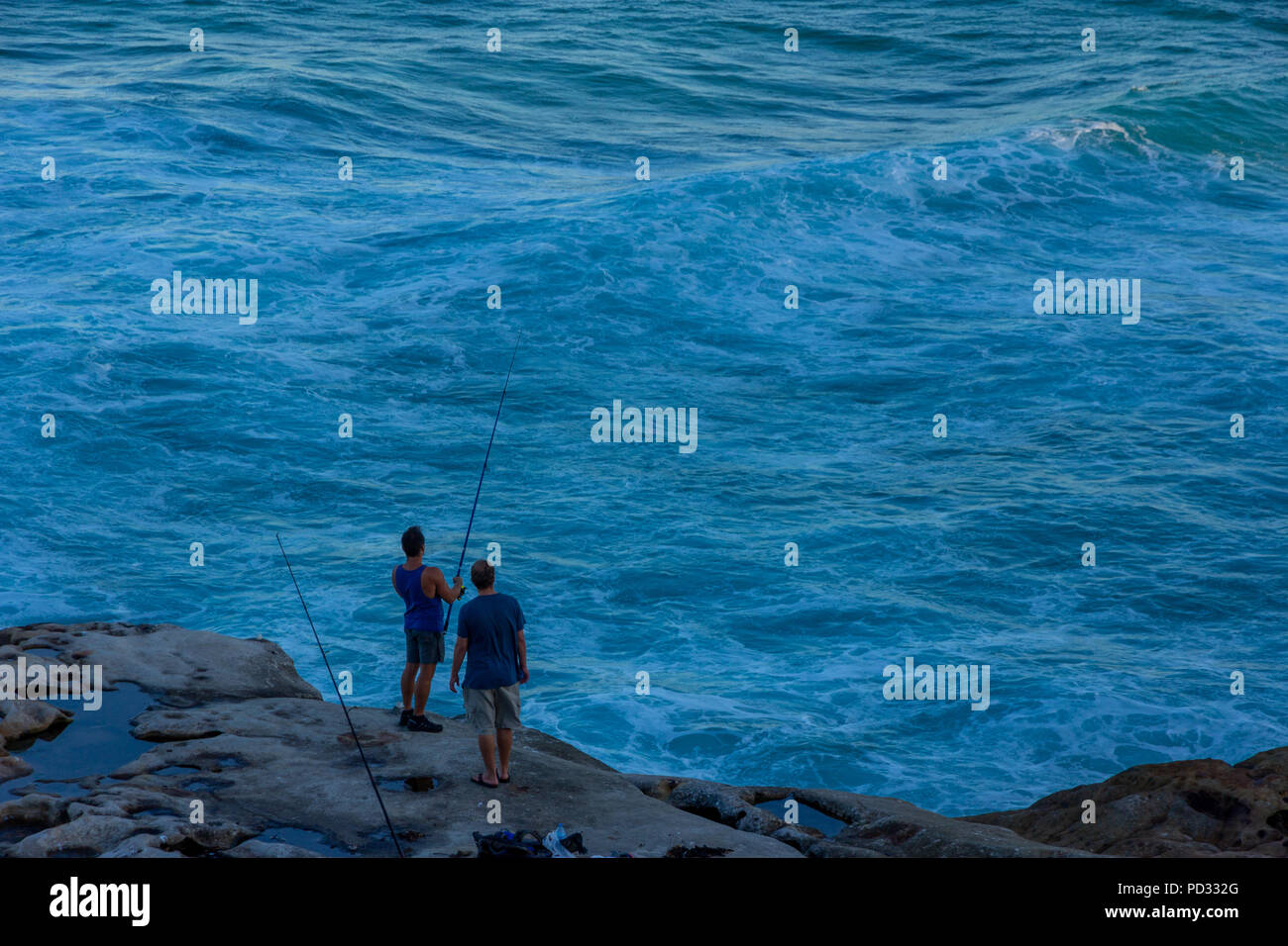 Two Tourists Standing With Fishing Rod In Hand On The Edge Of Rock Cliff At Tamarama Beach Stock Photo Alamy