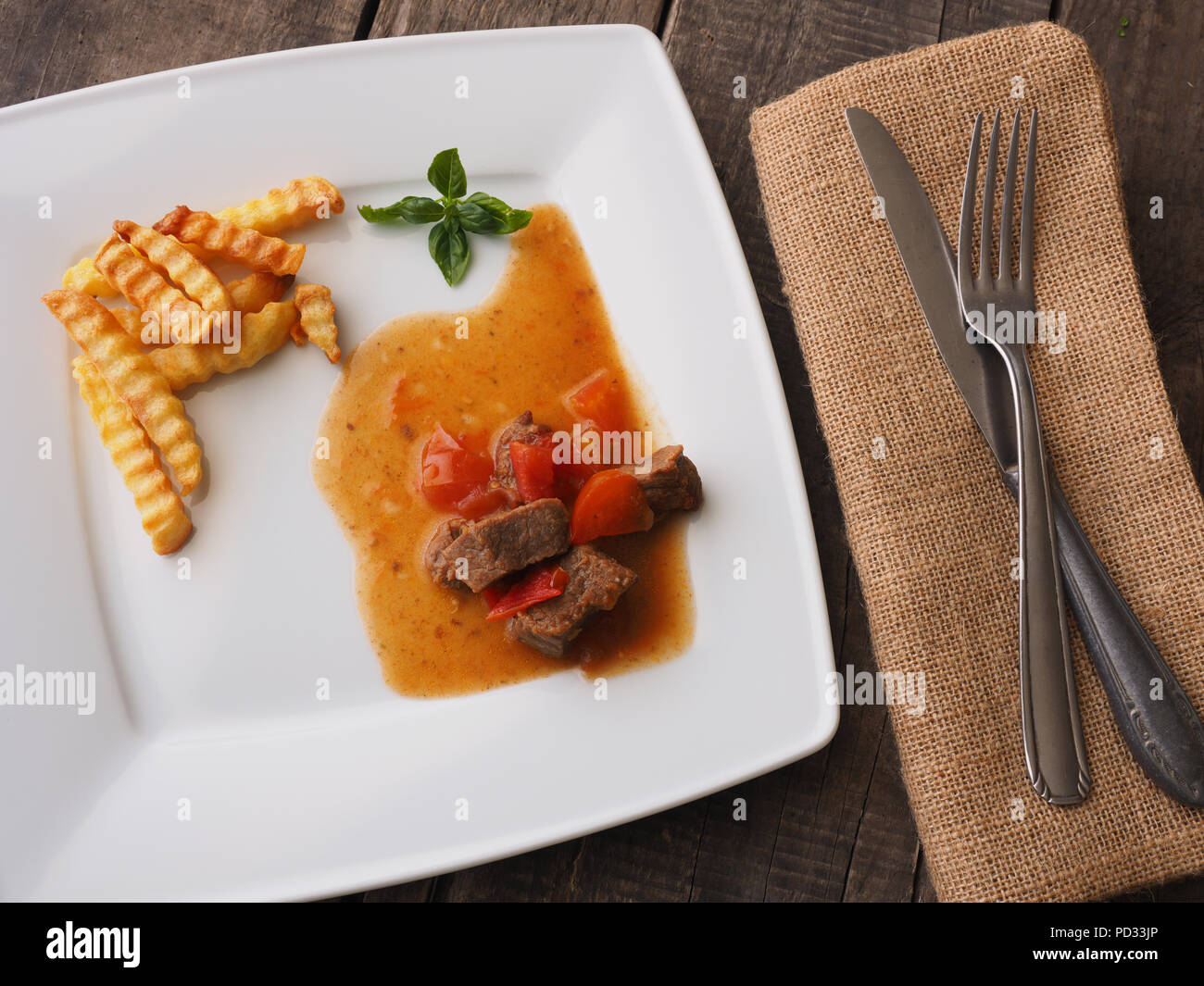 Tasty goulash of organic beef with French fries on a white plate Stock Photo