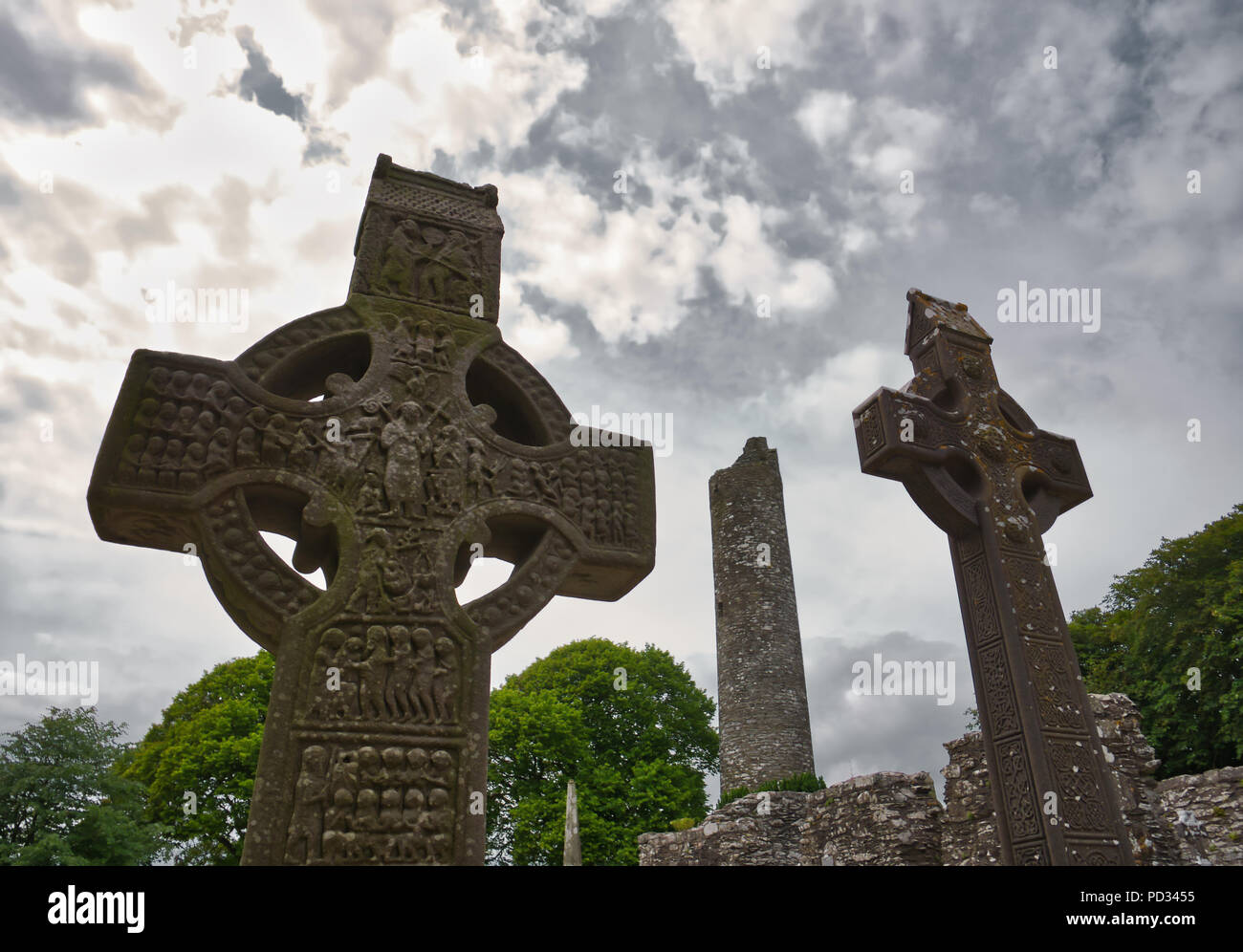 Two very high sandstone crosses in the cemetery with the famous round tower of Monasterboice in the background Stock Photo