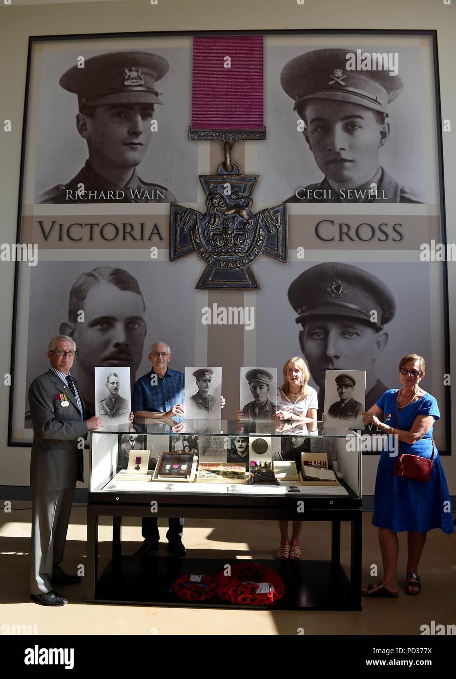 Bovington, UK. 6th August 2018. For the first time in history the four Victoria Crosses awarded to tank crews in the First World War are being brought together at The Tank Museum in Bovington, Dorset  left to right, holding pictures of their respective family mambers are, Ian Robertson with Captain Clement Robertson, Peter Harbinson with Captain Richard Wain, Wendy Shaw with Lt Cecil Sewell and Kitty Morris with Lt Col Richard West Credit: Finnbarr Webster/Alamy Live News Stock Photo
