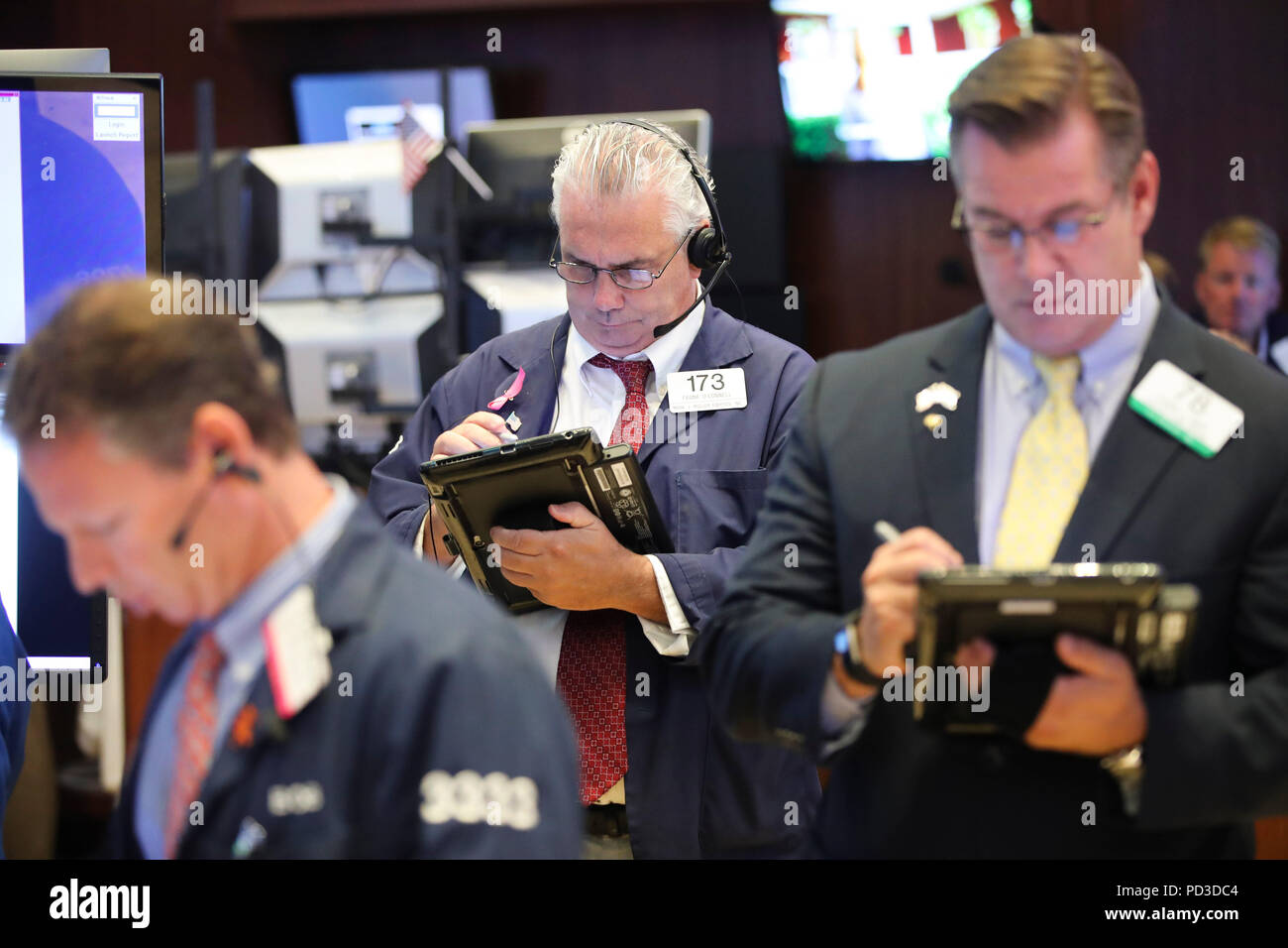 New York, USA. 6th Aug, 2018. Traders work at the New York Stock Exchange in New York, the United States, Aug. 6, 2018. U.S. stocks closed higher on Monday as investors digested a batch of second-quarter corporate earnings reports. The Dow Jones Industrial Average rose 39.60 points, or 0.16 percent, to 25,502.18. The S&P 500 increased 10.05 points, or 0.35 percent, to 2,850.40. The Nasdaq Composite Index rose 47.66 points, or 0.61 percent, to 7,859.68. Credit: Wang Ying/Xinhua/Alamy Live News Stock Photo
