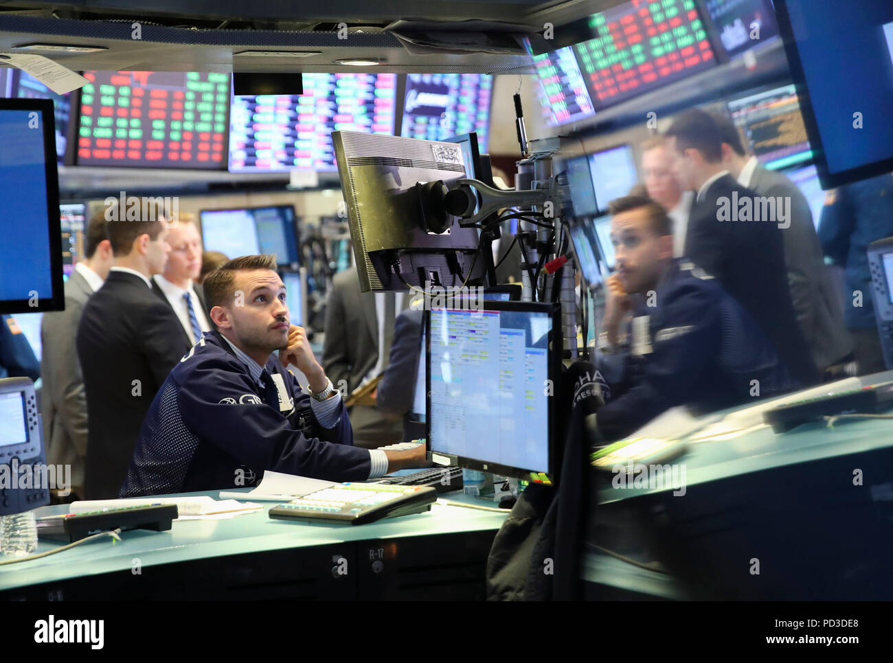 New York, USA. 6th Aug, 2018. Traders work at the New York Stock Exchange in New York, the United States, Aug. 6, 2018. U.S. stocks closed higher on Monday as investors digested a batch of second-quarter corporate earnings reports. The Dow Jones Industrial Average rose 39.60 points, or 0.16 percent, to 25,502.18. The S&P 500 increased 10.05 points, or 0.35 percent, to 2,850.40. The Nasdaq Composite Index rose 47.66 points, or 0.61 percent, to 7,859.68. Credit: Wang Ying/Xinhua/Alamy Live News Stock Photo