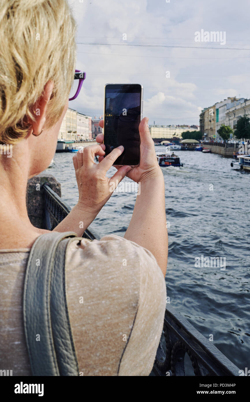 Anonymous woman taking picture on embankment Stock Photo