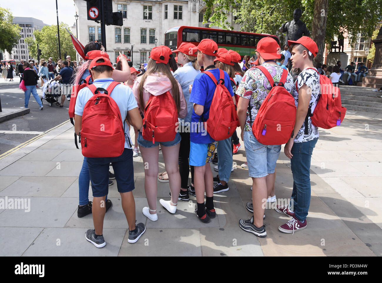Group of teenage school children on a sightseeing trip,Parliament Square,London.UK Stock Photo