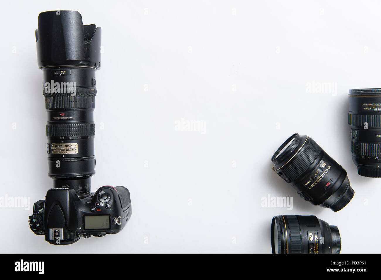 Top down view of camera equipment on white tabletop, DSLR with